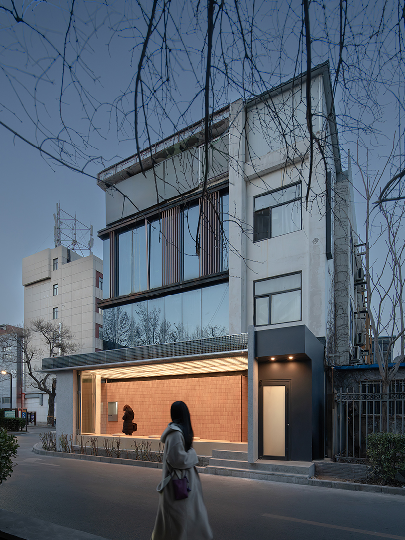 lantern-like lighting shines through suspended metal grid within tea pavilion in beijing