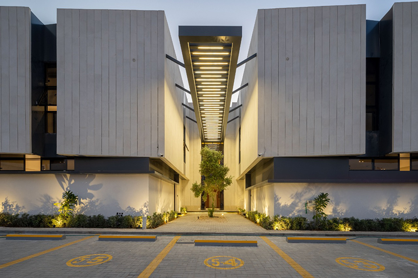 a series of timber-clad and concrete boxes compose courtyard houses in saudi arabia