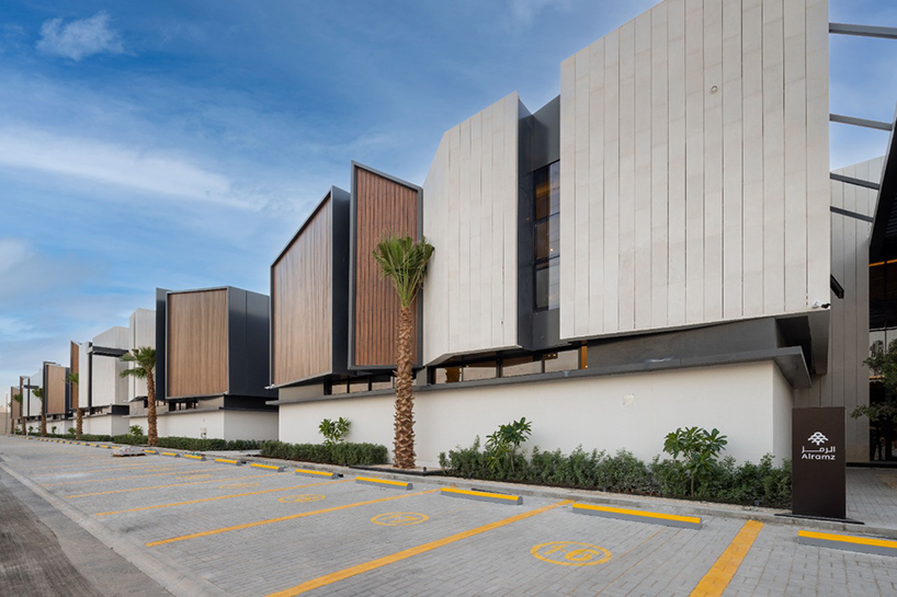 a series of timber-clad and concrete boxes compose courtyard houses in saudi arabia