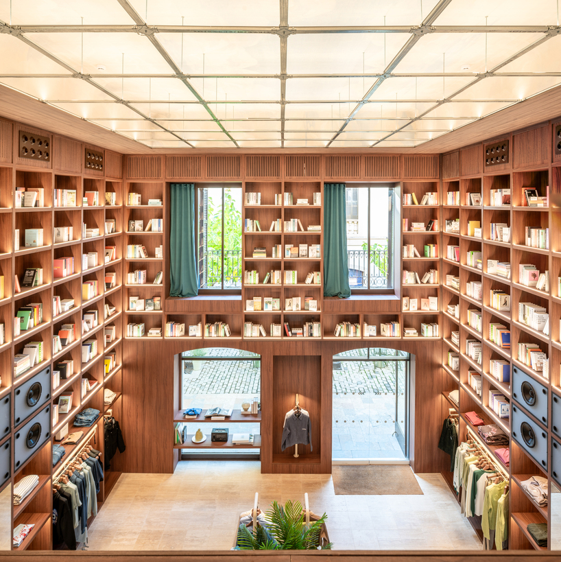 el departamento installs massive wooden bookshelf for nude project's new store in barcelona