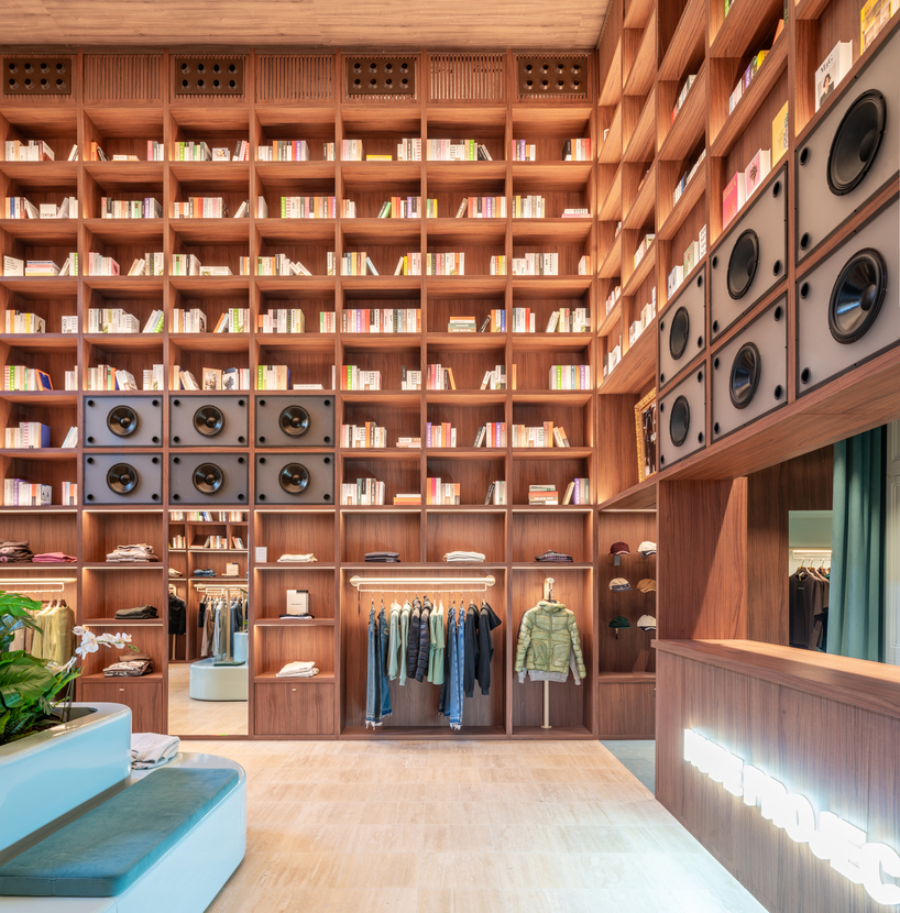 el departamento installs massive wooden bookshelf for nude project's new store in barcelona