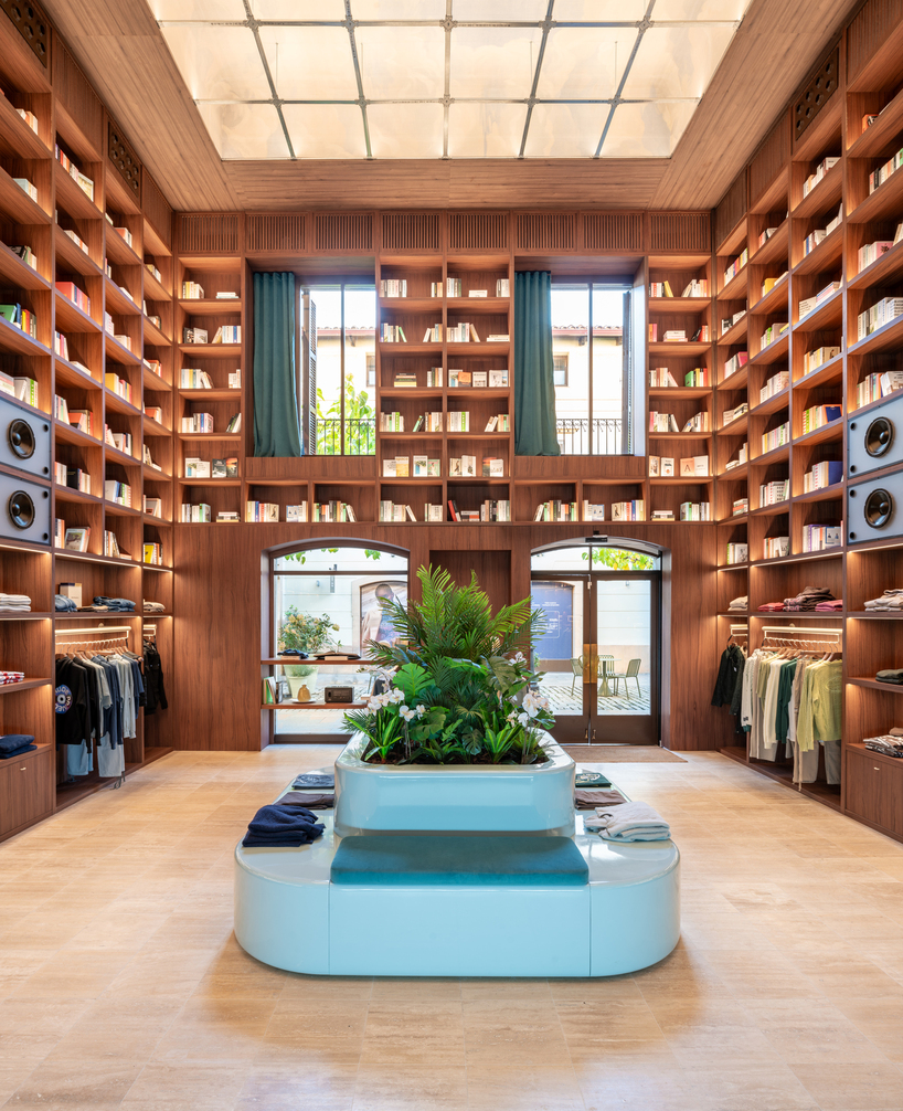 el departamento installs massive wooden bookshelf for nude project's new store in barcelona