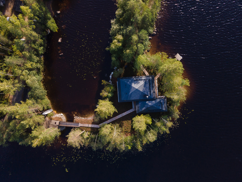 ecological wooden cabin nestles in rural finland's lakeside setting