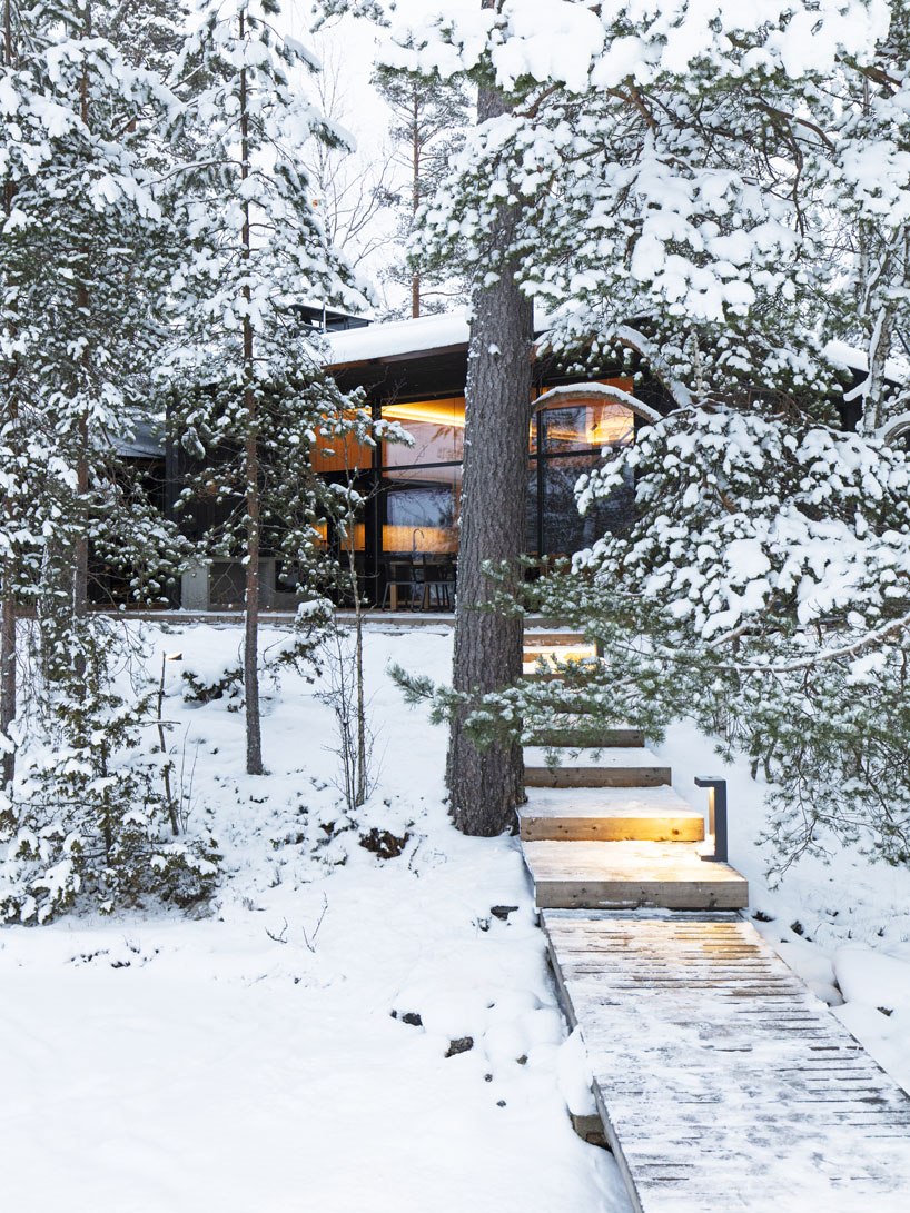 ecological wooden cabin nestles in rural finland's lakeside setting