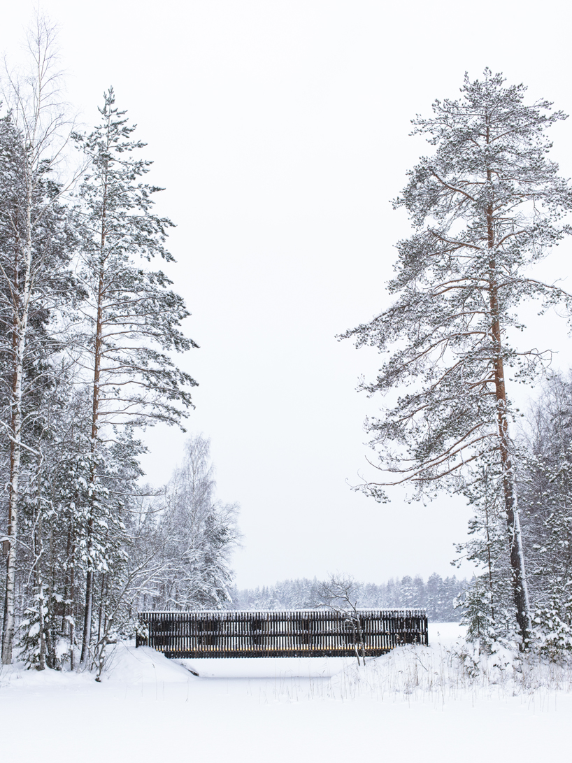 ecological wooden cabin nestles in rural finland's lakeside setting