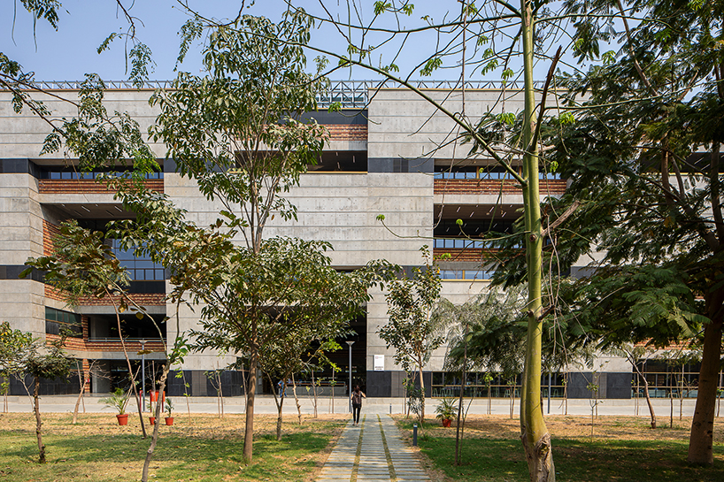 playfully stacked geometric concrete volumes compose student facility in india