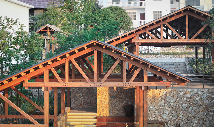 continuous gabled roof tops galaxy arch's wood-framed community space in chinese village