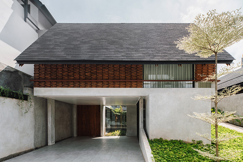 red brick lace-like facade coats the mass of ach house in south jakarta