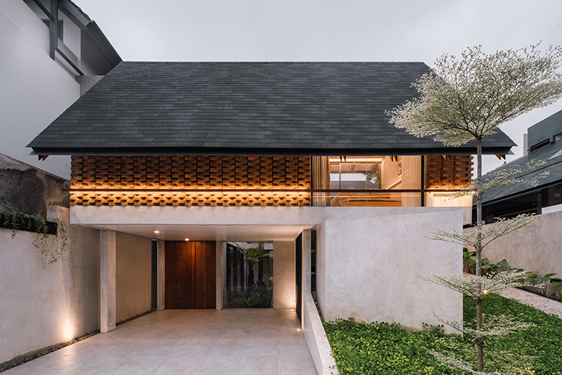 red brick lace-like facade coats the mass of ach house in south jakarta