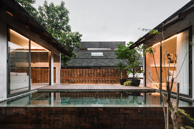 red brick lace-like facade coats the mass of ach house in south jakarta