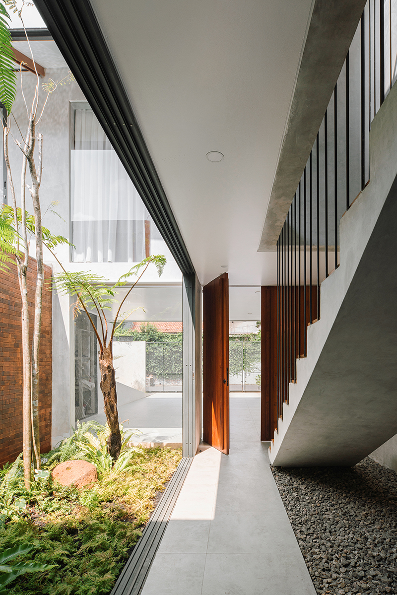 red brick lace-like facade coats the mass of ach house in south jakarta