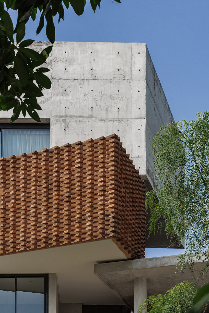 Exposed concrete and brick form the facade of YSH House in Central Java