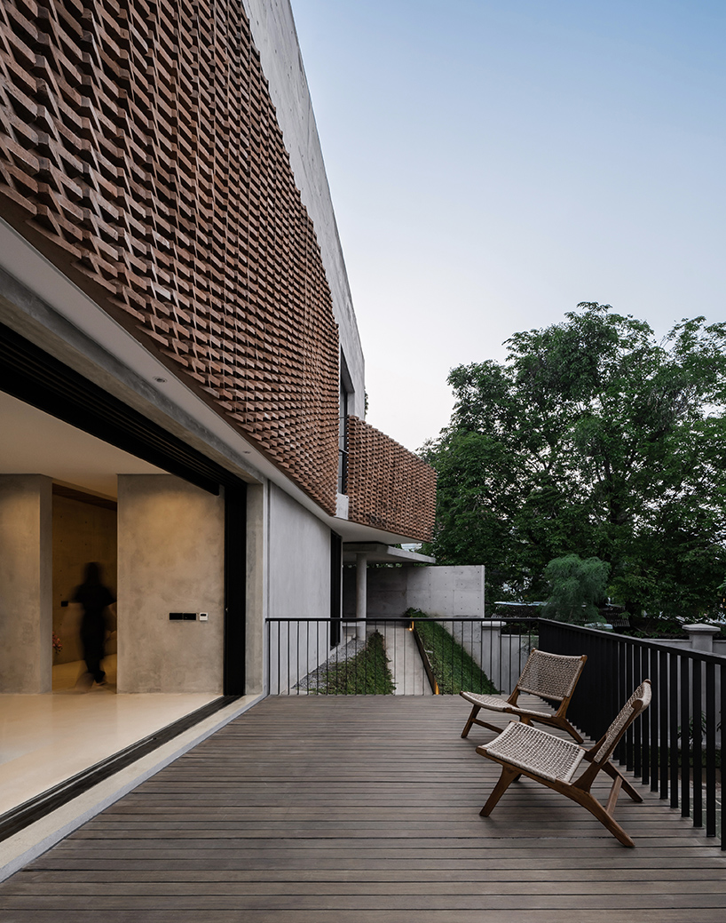 Exposed concrete and brick form the facade of YSH House in Central Java