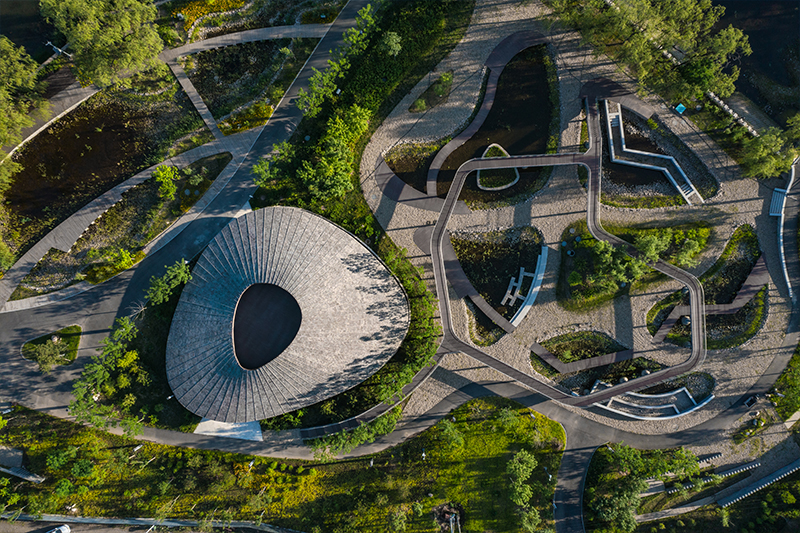 sculptural roof informs the ring-shaped design of lake education center in china