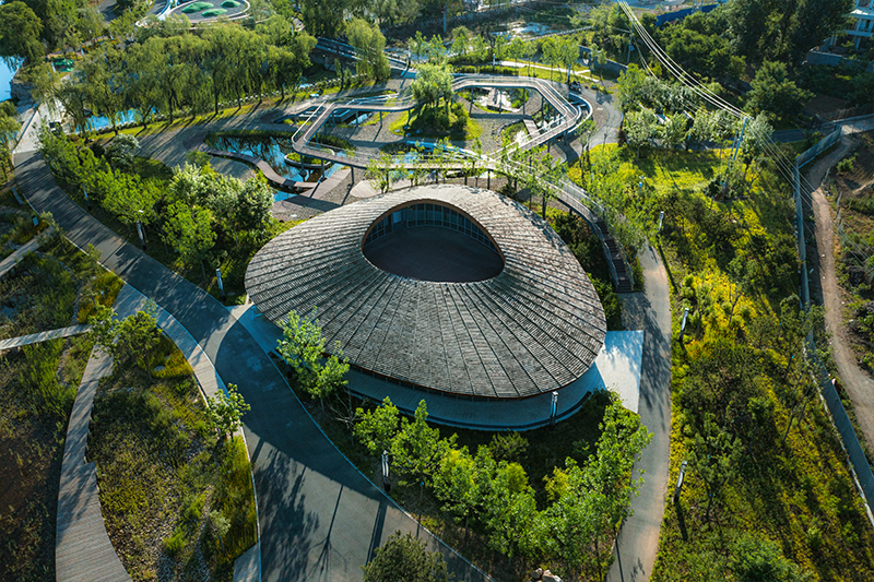 sculptural roof informs the ring-shaped design of lake education center in china