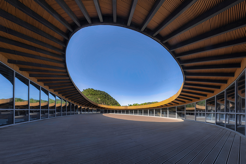 sculptural roof informs the ring-shaped design of lake education center in china