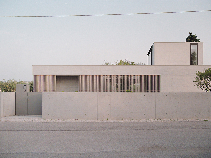 exposed concrete volumes and sliding wooden shutters compose Didonè Comacchio Architects' house nf in italy