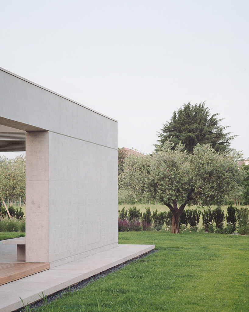 exposed concrete volumes and sliding wooden shutters compose Didonè Comacchio Architects' house nf in italy