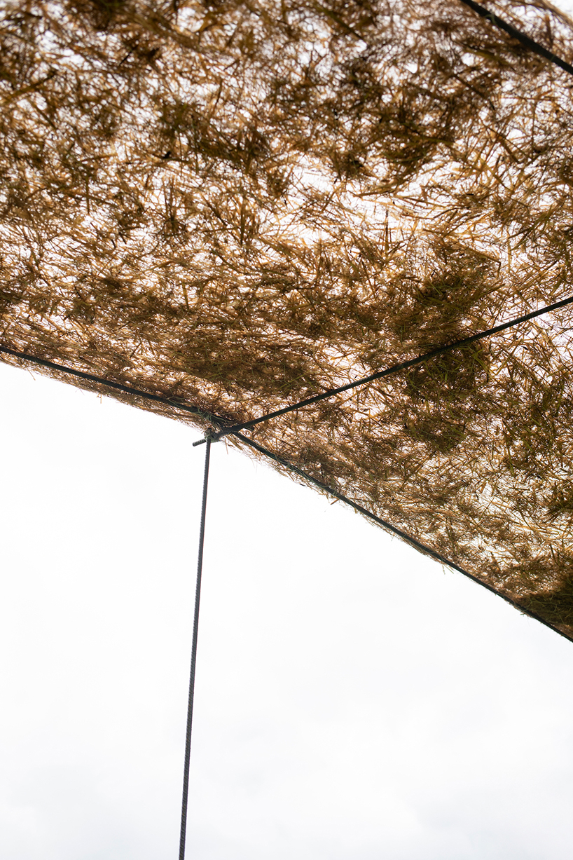 hay bales unroll into trace of land installation across alpine terrain in italy