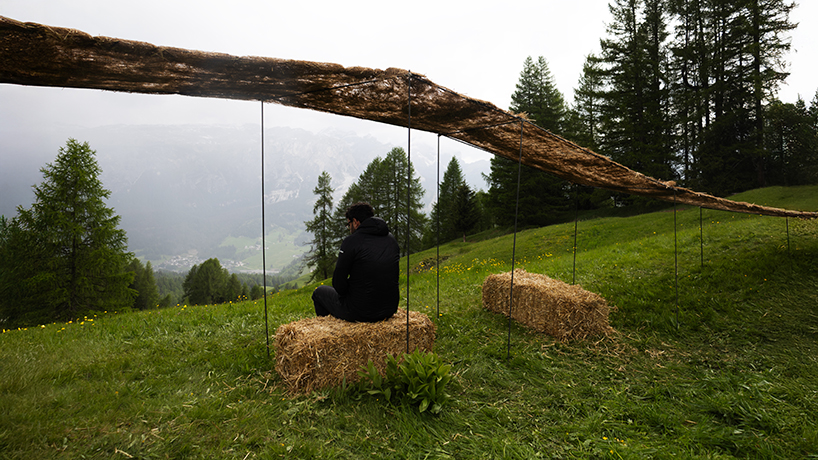 hay bales unroll into trace of land installation across alpine terrain in italy