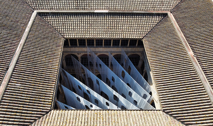 Cortinas de organza translúcidas flotan dentro de un patio abovedado del Renacimiento español
