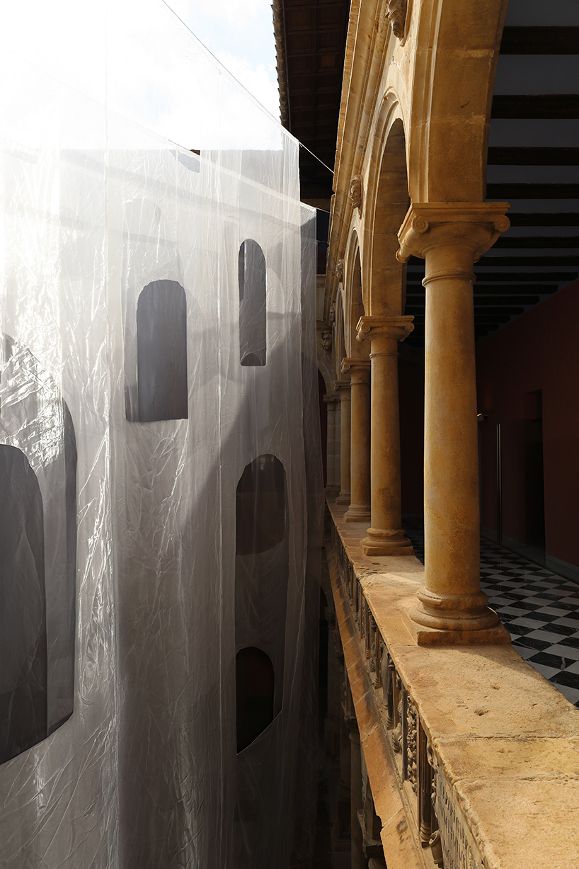 translucent organza curtains float within renaissance arched courtyard in spain