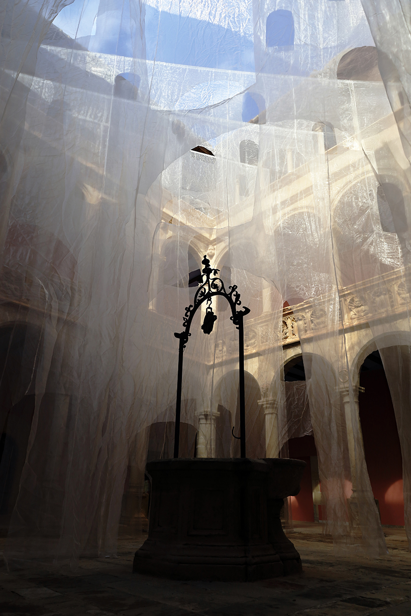 translucent organza curtains float within renaissance arched courtyard in spain