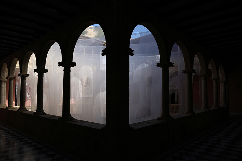 translucent organza curtains float within renaissance arched courtyard in spain