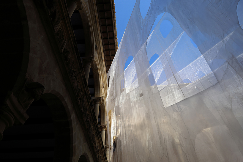 translucent organza curtains float within renaissance arched courtyard in spain