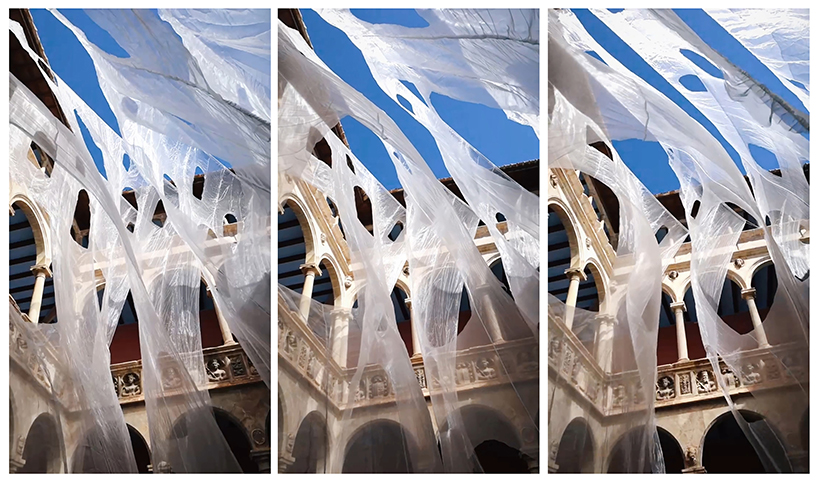 translucent organza curtains float within renaissance arched courtyard in spain