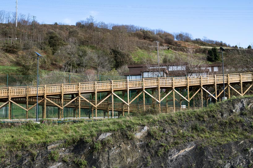 pedestrian wooden walkway on stilts traces hillside in bilbao