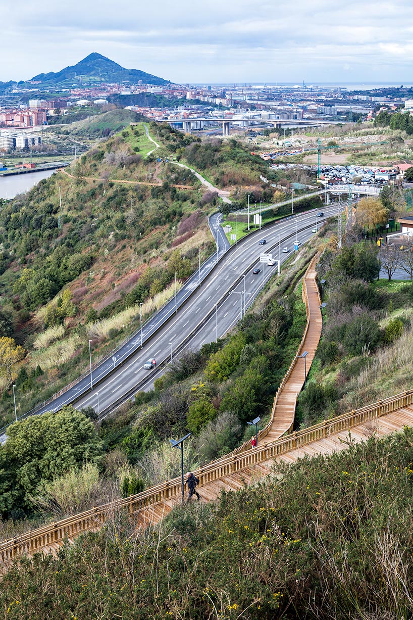 pedestrian wooden walkway on stilts traces hillside in bilbao