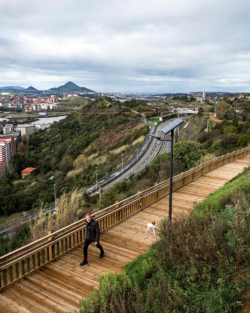 pedestrian wooden walkway on stilts traces hillside in bilbao