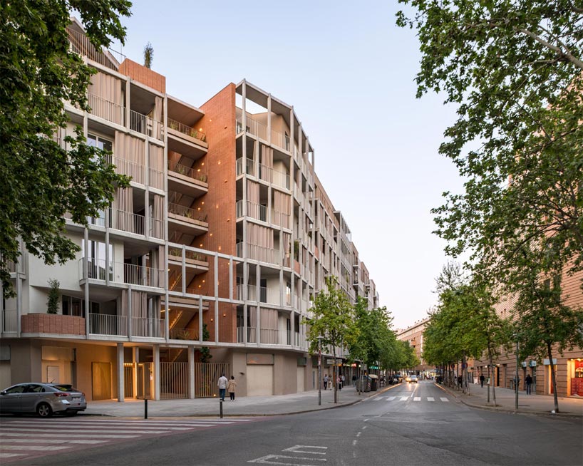 multi-storey corner residential building in Barcelona has an open, green courtyard