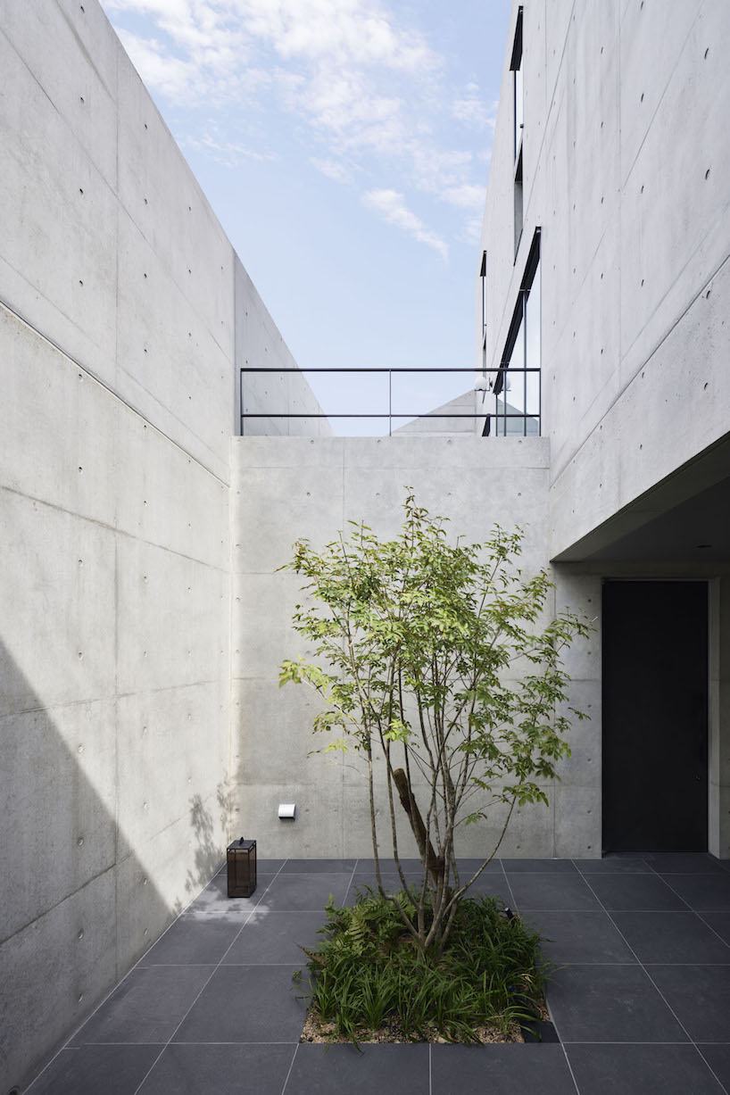 dynamic curtain of concrete walls of varying heights engulfs japanese home by GOSIZE in tranquility