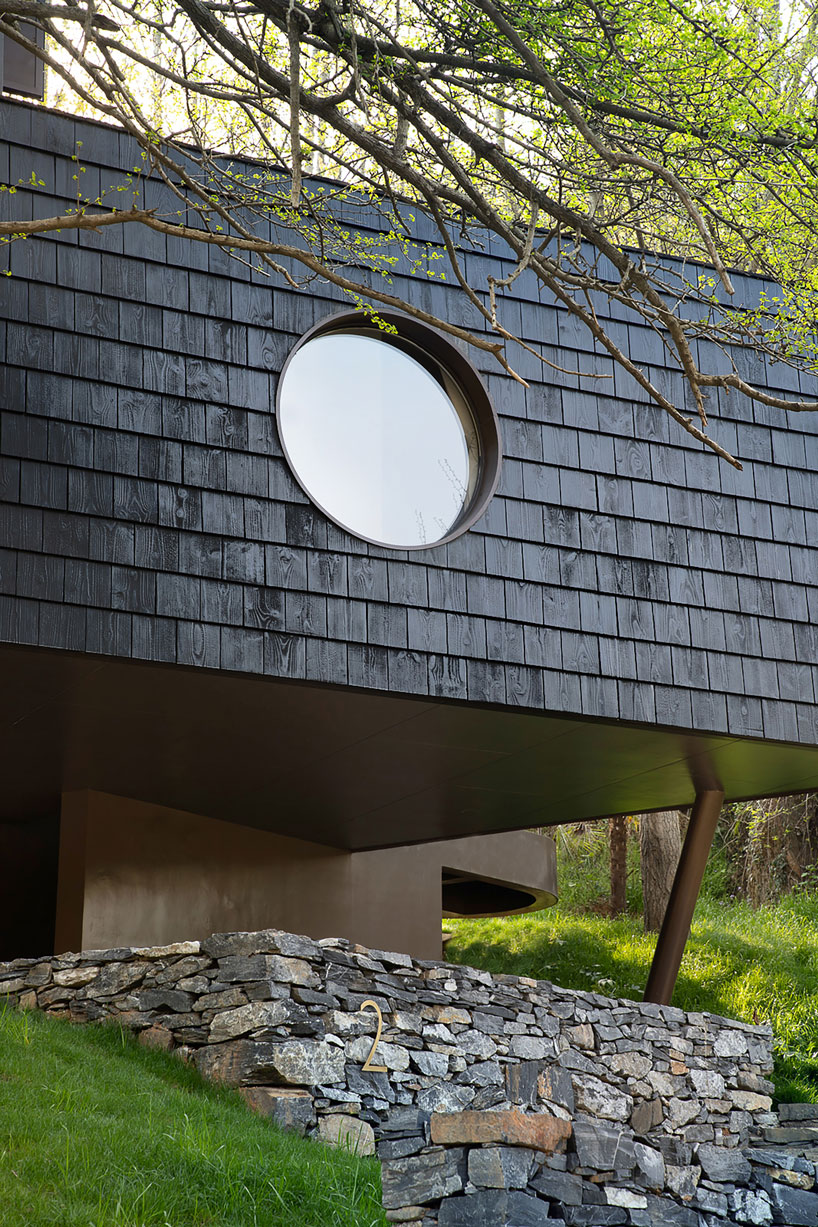 geometric openings pierce elevated treehouse clad in charred cedar planks in hubei