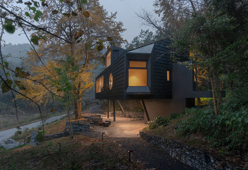 geometric openings pierce elevated treehouse clad in charred cedar planks in hubei