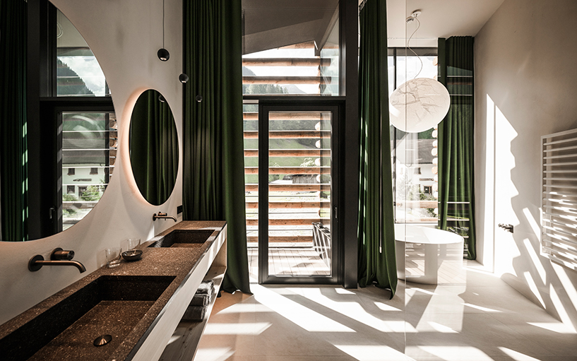 DEAR studio adapts old hay barns into modern larch log-clad hotel in italian alps