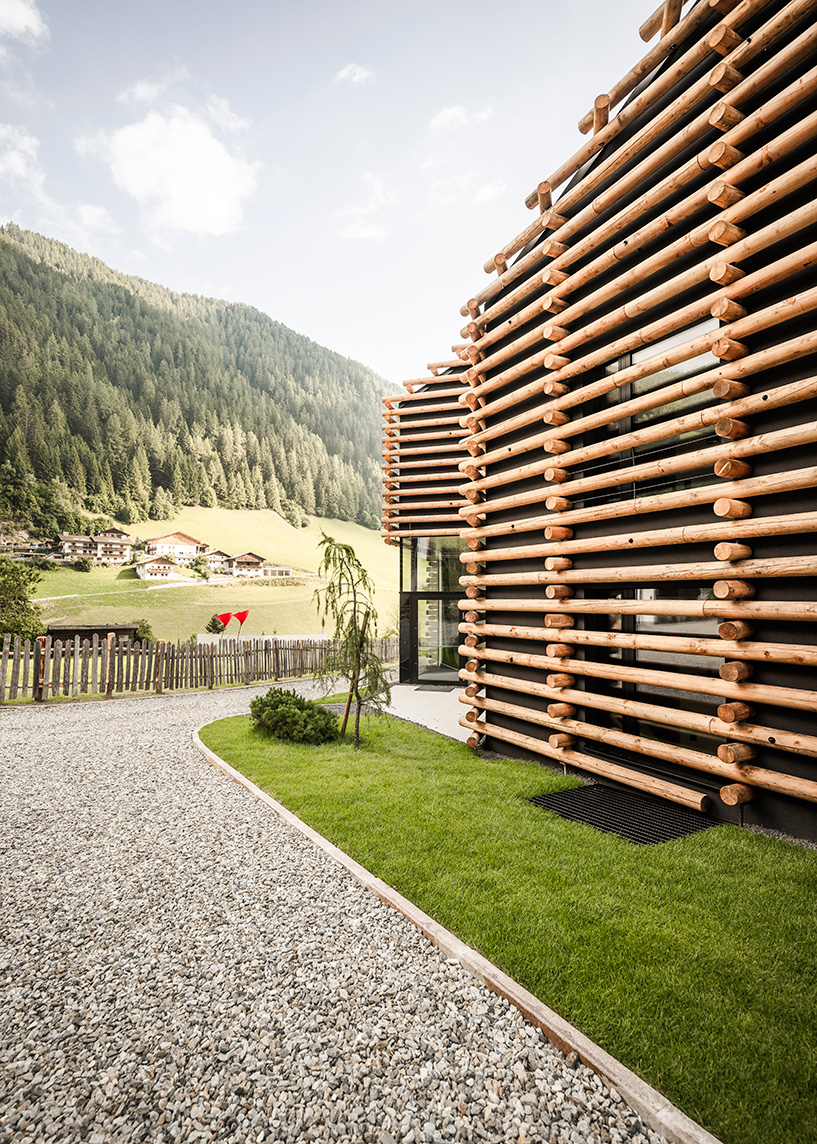 DEAR studio adapts old hay barns into modern larch log-clad hotel in italian alps