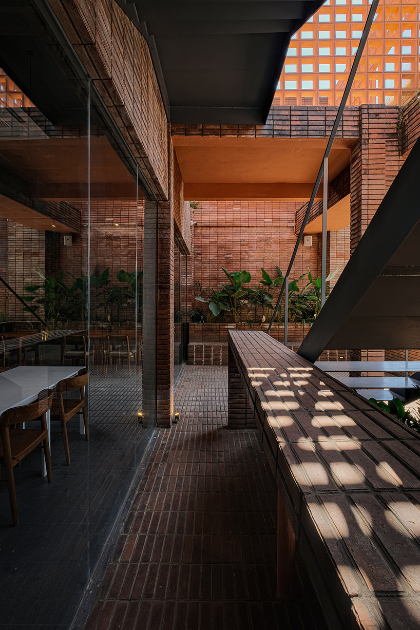 local stone, brick and terracotta screens layer across three-story gathering space in indonesia - 6