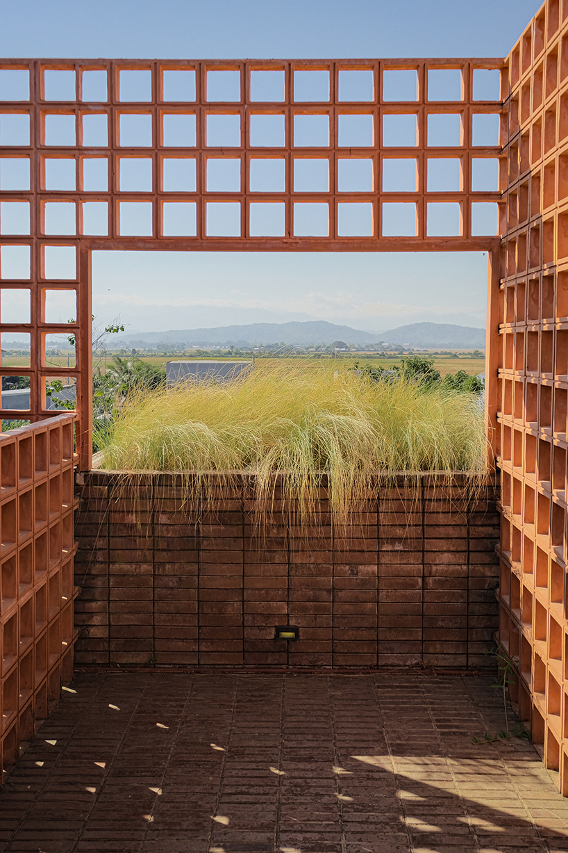 local stone, brick and terracotta screens layer across three-story gathering space in indonesia - 3