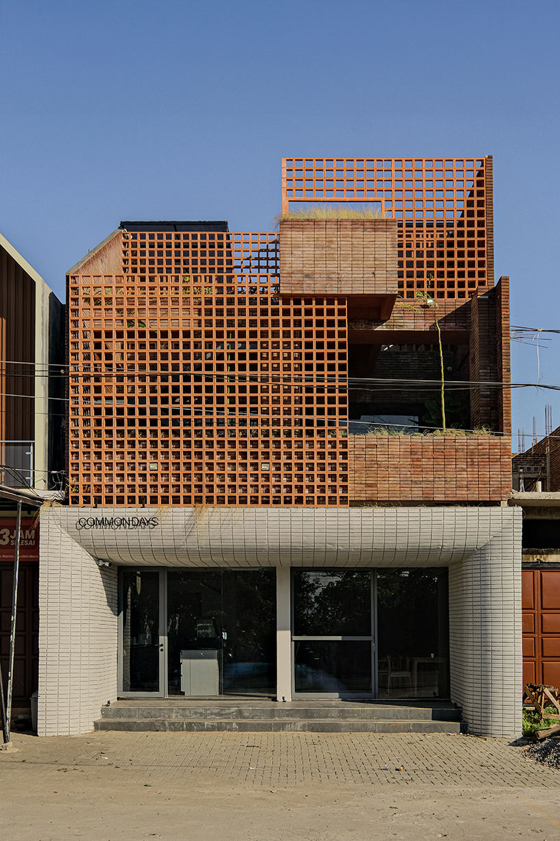 local stone, brick and terracotta screens layer across three-story gathering space in indonesia - 1