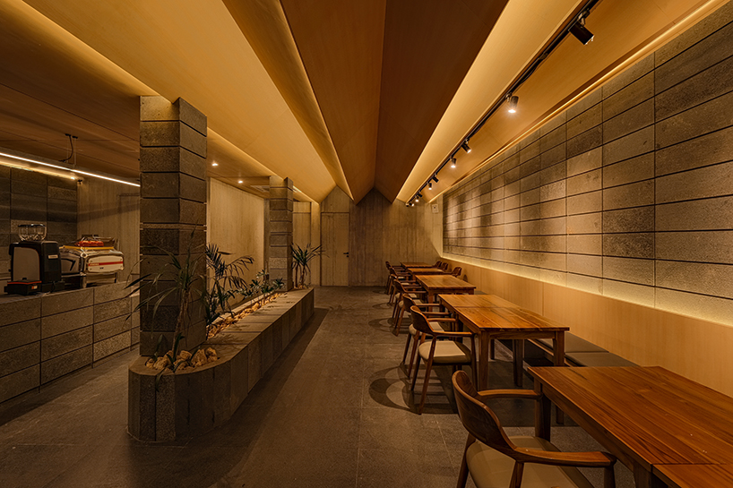 local stone, brick and terracotta screens layer across three-story gathering space in indonesia - 9
