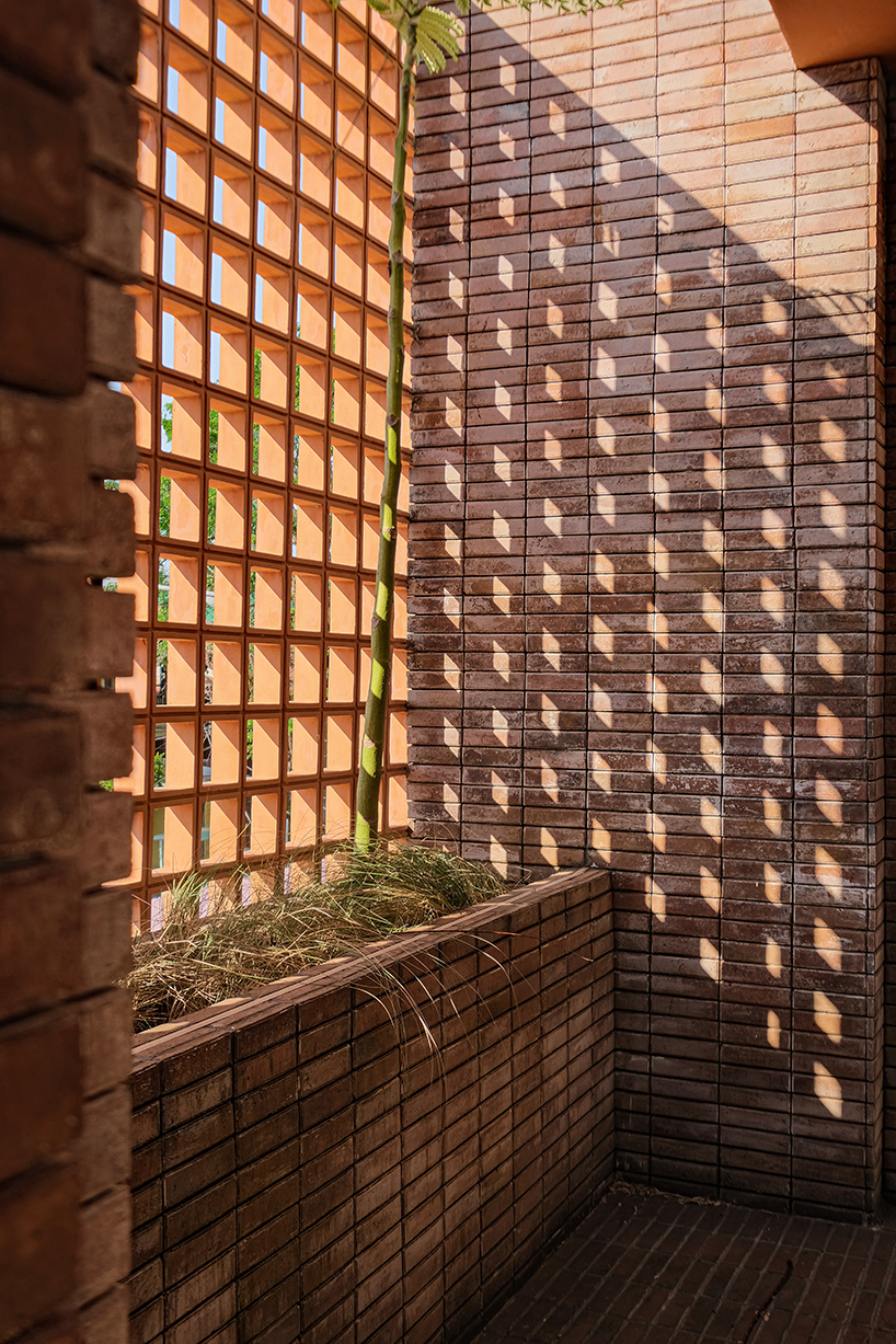 local stone, brick and terracotta screens layer across three-story gathering space in indonesia - 5