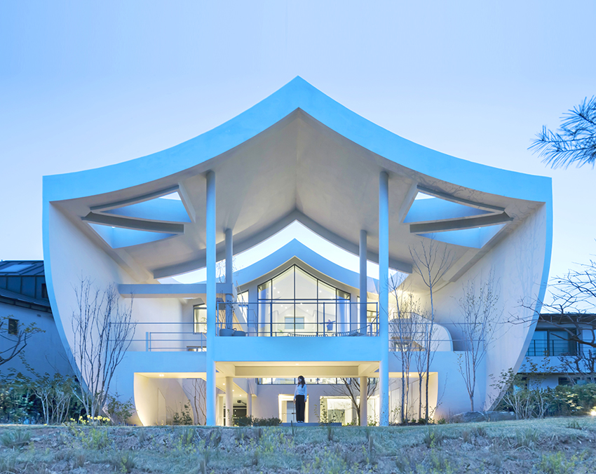 curved eave roofs shape IROJE KHM’s white lakeside residence in south korea