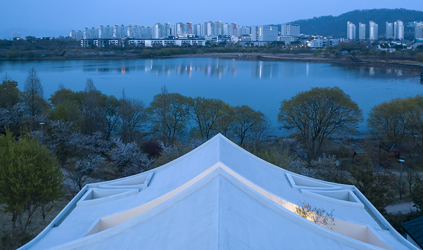 curved eave roofs shape IROJE KHM’s white lakeside residence in south korea