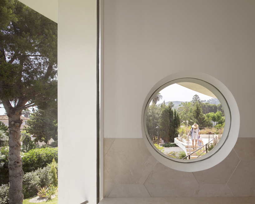 curved white volumes and verdant surroundings define house in les rotes, spain