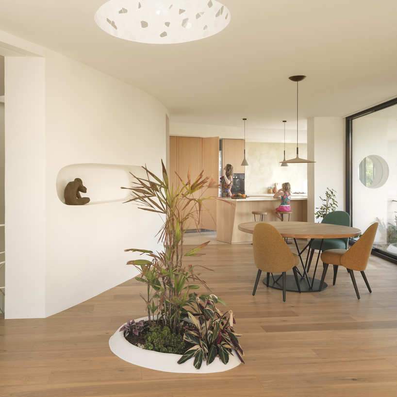 curved white volumes and verdant surroundings define house in les rotes, spain