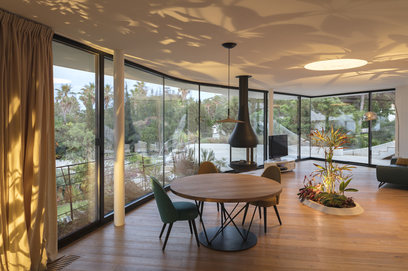 curved white volumes and verdant surroundings define house in les rotes, spain