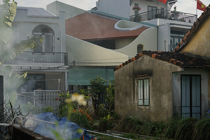 curved cutouts sculpt fluid voids within gabled residence in vietnam